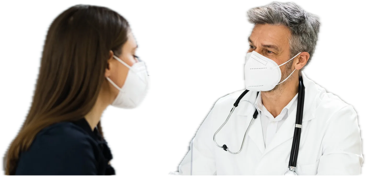 Patientin und Arzt im Gespräch in einer Praxis, beide tragen eine FFP2-Maske
